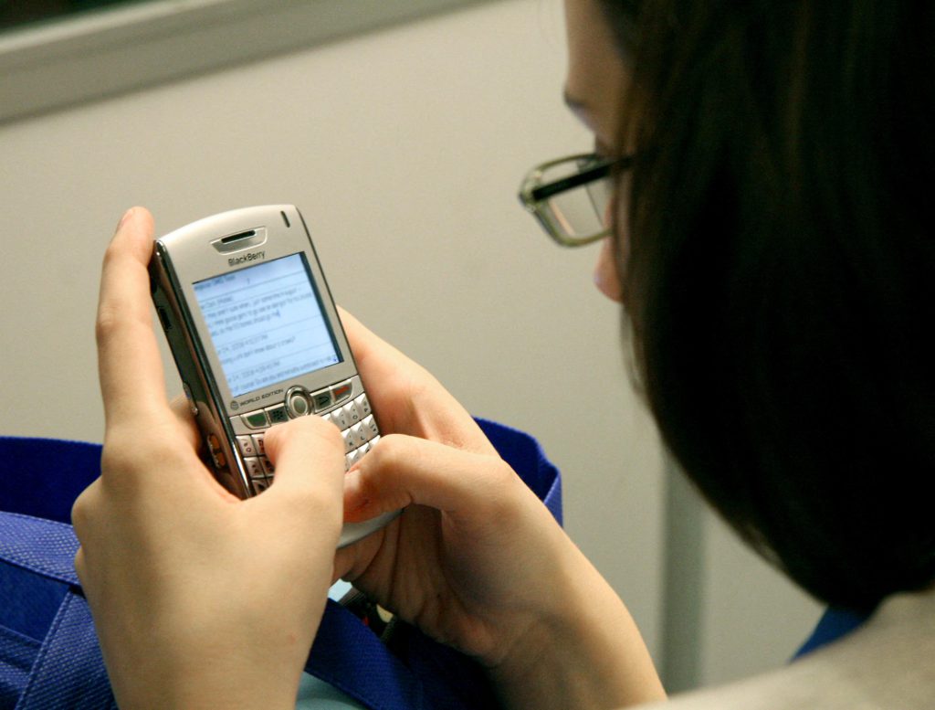 Mujer escribiendo en telefono celular