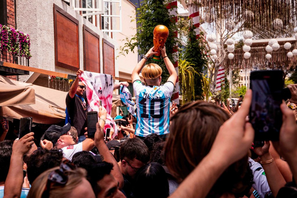 Hincha con camiseta de Messi rodeado de personas que graban con sus celulares.